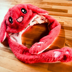 Red plush rabbit hat with long floppy ears, paw-shaped flaps, embroidered face, and white inner ear lining