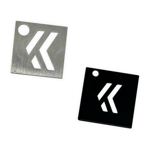 Two square steel KevinAkaSam logo keychains in brushed silver and black finishes